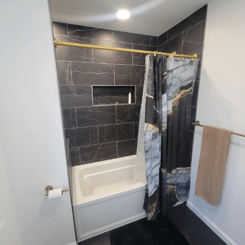 Finished bathroom renovation showing marble-pattern tile and bright recessed lighting by Homes by Covenant Forever