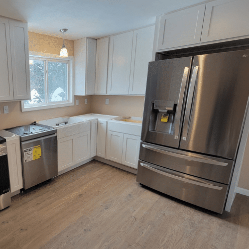 Renovated kitchen with new cabinetry, flooring, and appliances completed by Homes by Covenant