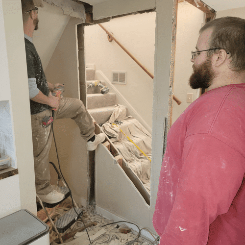 Homes by Covenant renovation team working on basement remodel and drywall installation`