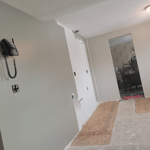 Bedroom renovation in progress with new drywall and flooring installation by Homes by Covenant`