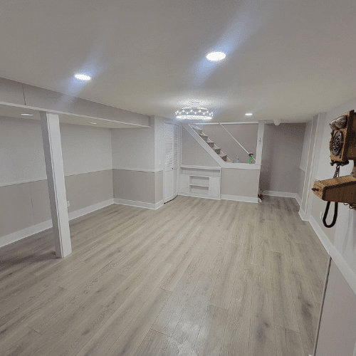 Spacious finished basement showing new flooring, lighting, and custom woodwork by Homes by Covenant
