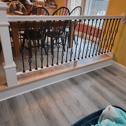 Dining area renovation featuring custom railing and new flooring by Homes by Covenant