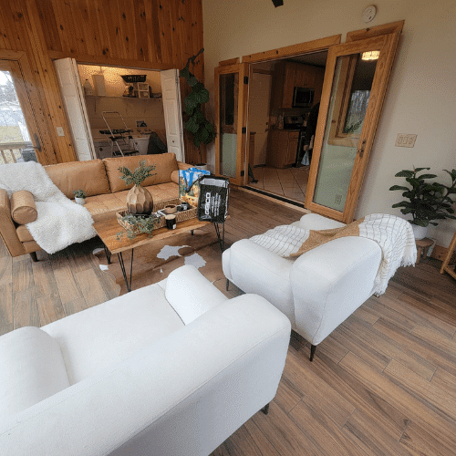 Completed living room renovation with wood-paneled walls and modern furniture by Homes by Covenant