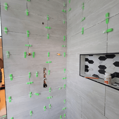 Tile installation in progress for shower renovation managed by Homes by Covenant renovation specialists