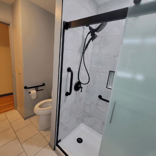 Accessible bathroom renovation featuring walk-in shower, grab bars, and updated fixtures by Homes by Covenant