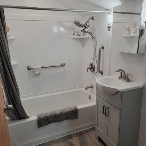 Finished bathroom remodel showing tub, fixtures, and bright modern design by Homes by Covenant