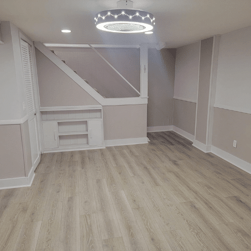 Finished basement living area with recessed lighting and custom trim work by Homes by Covenant