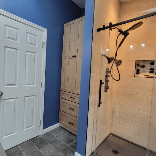 Bathroom remodel with blue accent walls, new vanity, and tile flooring completed by Homes by Covenant