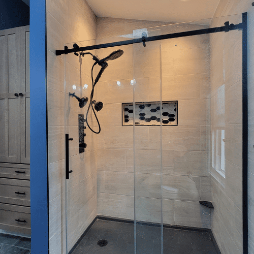 Completed walk-in shower remodel with tile walls and glass doors installed by Homes by Covenant