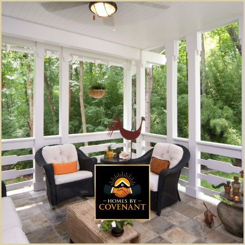 Enclosed porch with large windows, seating, and surrounding greenery in a home addition.