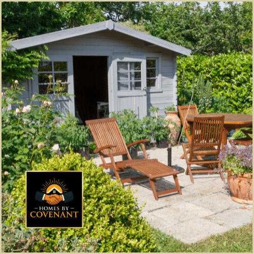 Cottage-style shed with white trim next to a patio seating area.